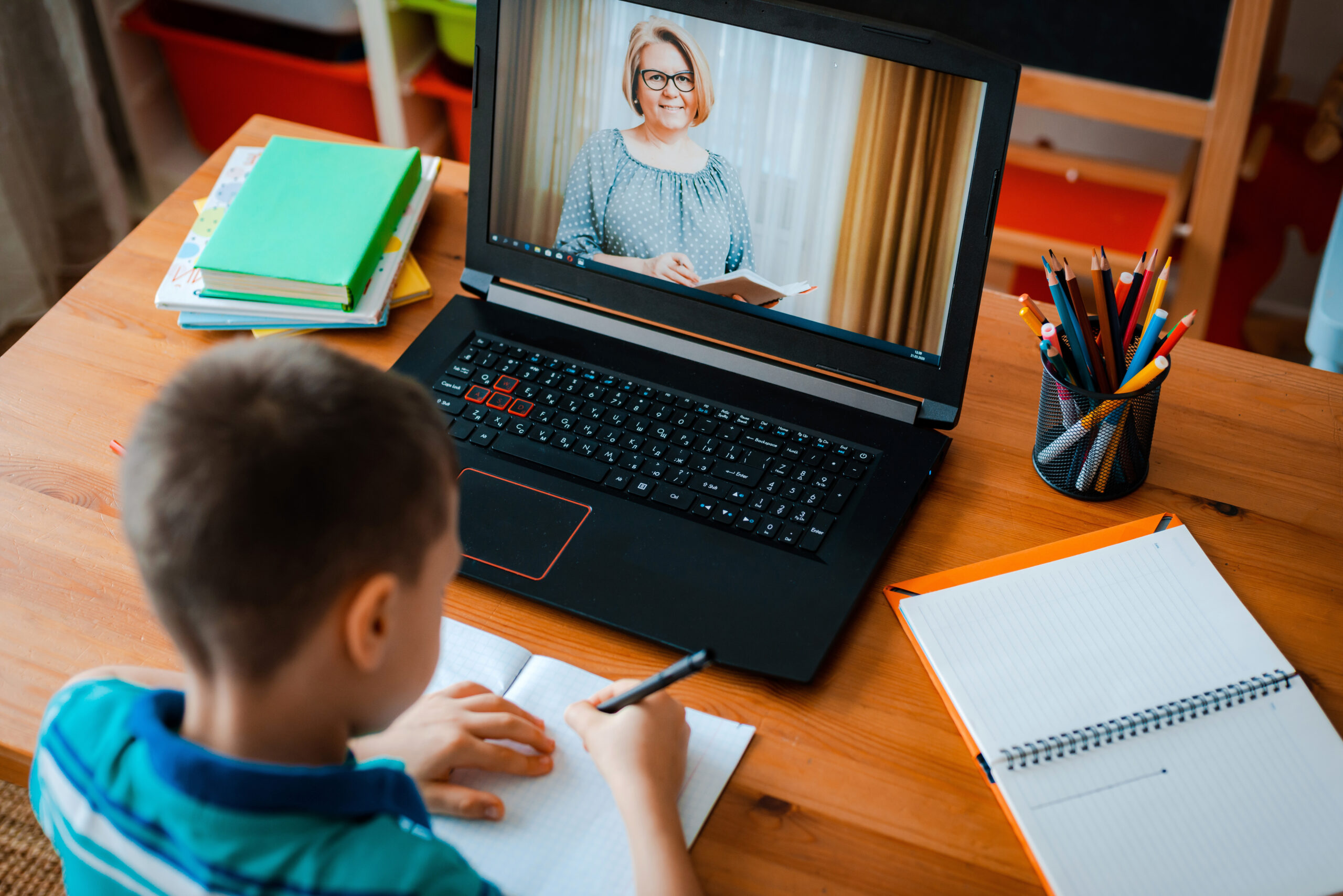 Distance learning online education. A schoolboy boy studies at home and does school homework. A home distance learning.